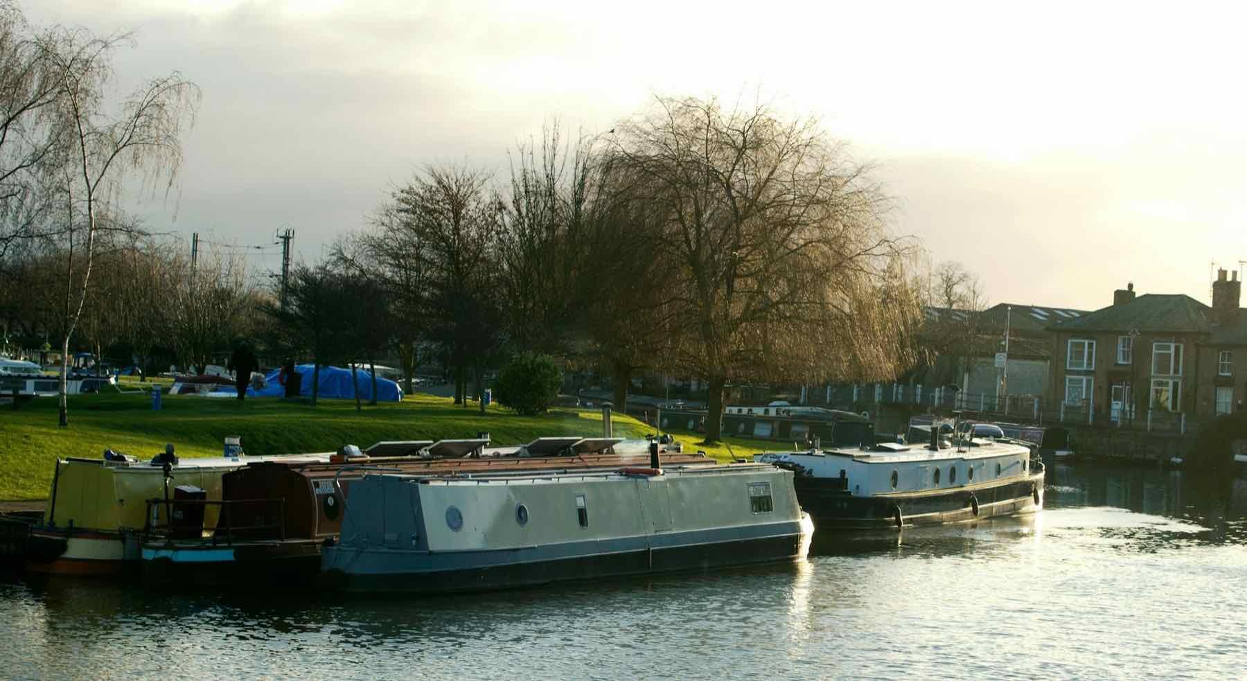 Boats moored on a river in low winter sun